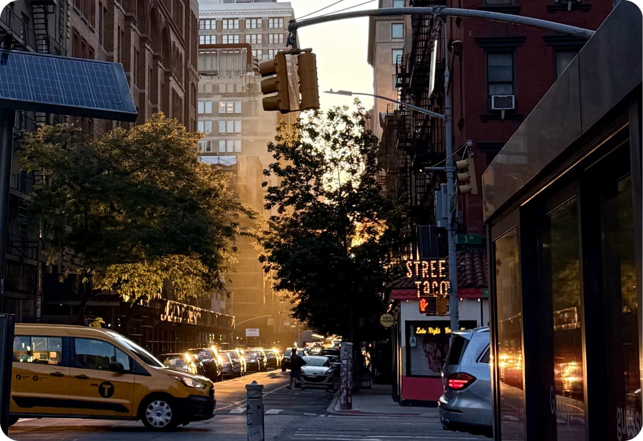 A busy street in Midtown Manhattan as the sun is setting.