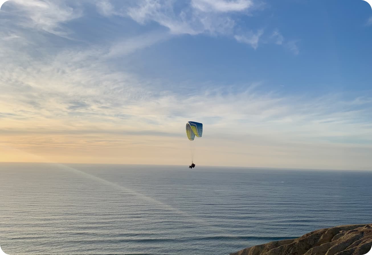 A paraglider soaring over the cliffs of La Jolla, California.