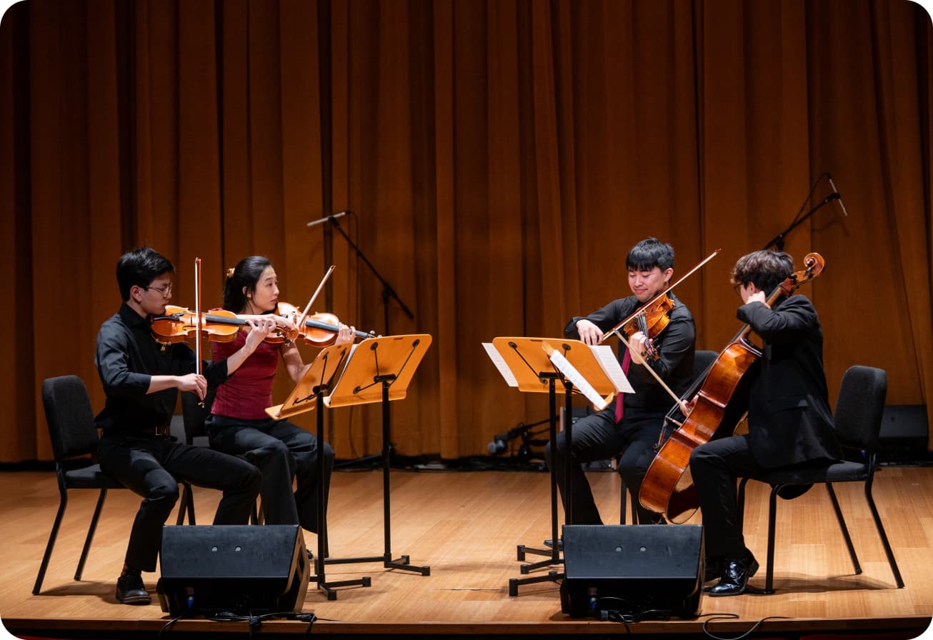 Alice and three other string quartet members performing on a stage.