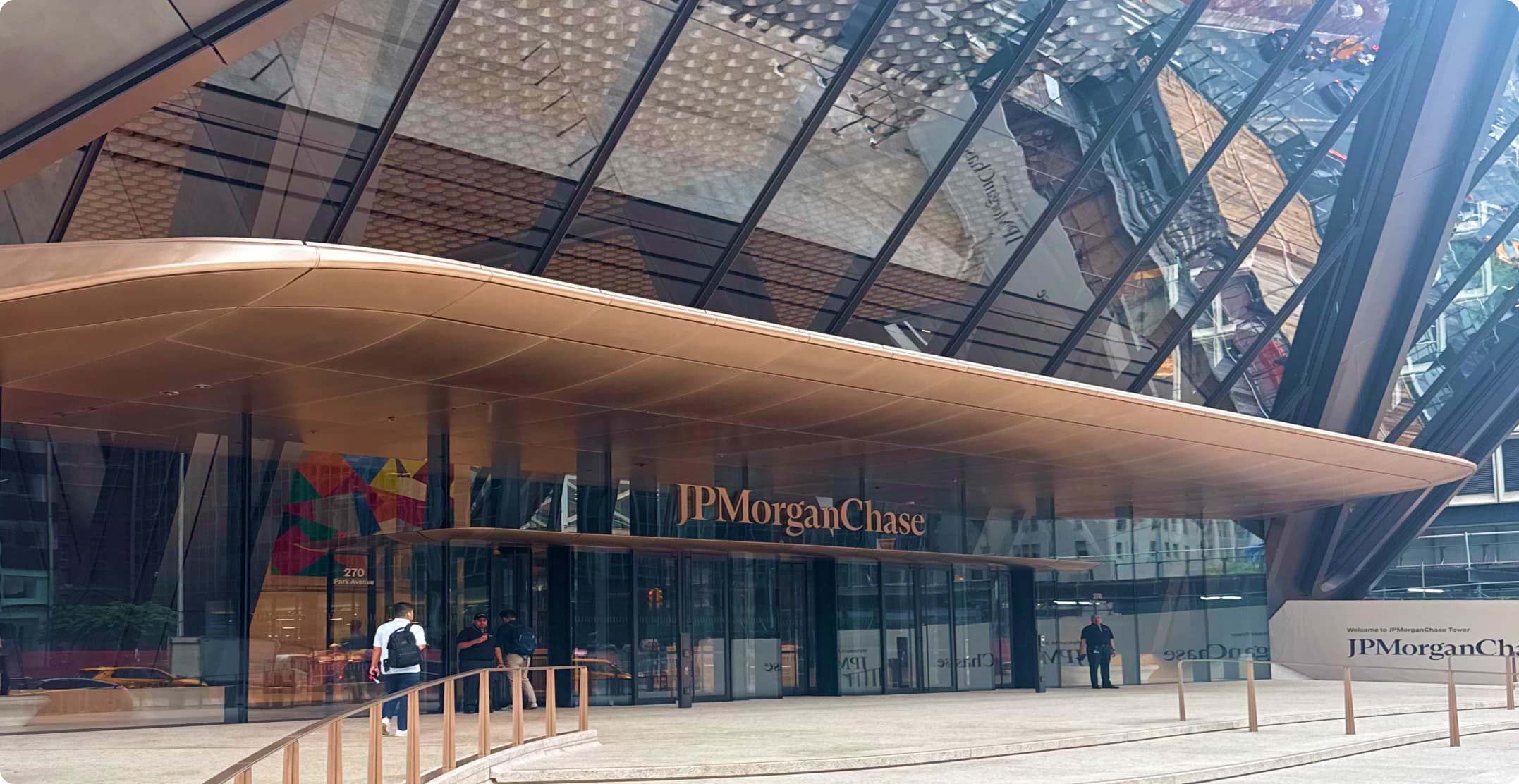 The glass-and-timber entrance canopy of a JPMorgan Chase office building, with the Chase wordmark and logo above the doors.